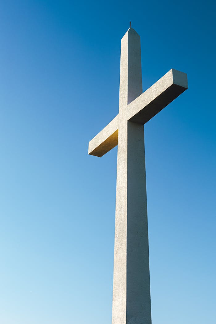A monumental cross against a clear blue sky symbolizing faith and spirituality.